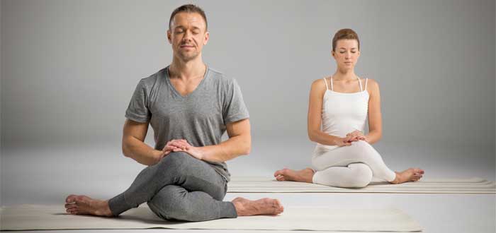 Un hombre y una mujer practicando yoga.